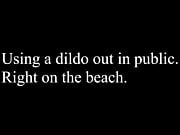 Using a dildo on the beach. 