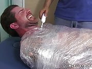 Jock Clint wrapped up to have his feet tickled BDSM style