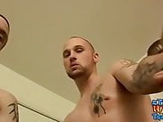 Muscular bald dude lays on the bed and pulls on his penis