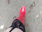 in red boots on a parking lot 
